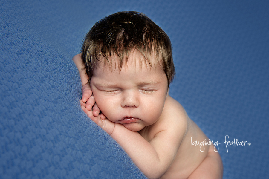 newborn baby on blue backdrop