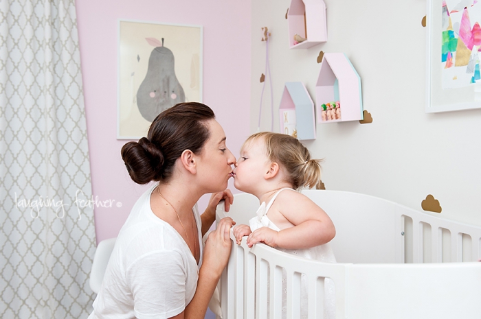 mother kissing daughter in bedroom